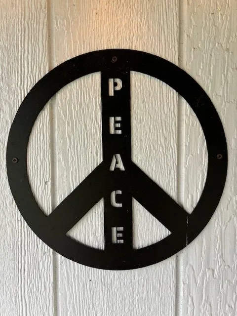 Metal peace sign on the cottage wall