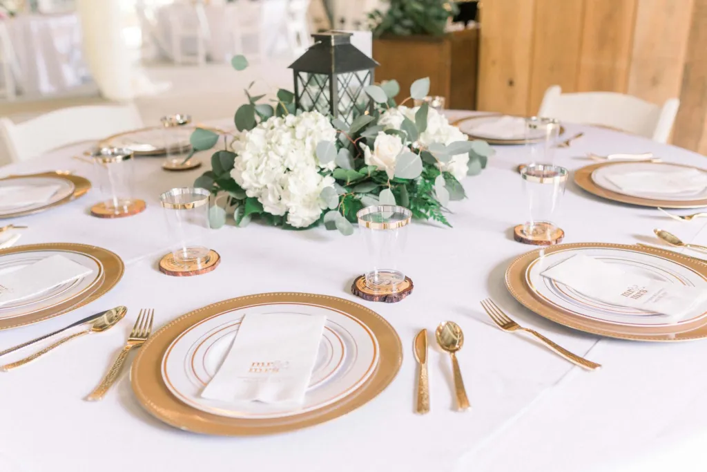 Gold-rimmed place settings and a white floral centerpiece